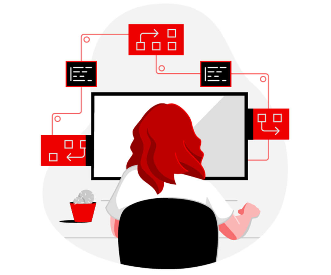 Persona con i capelli lunghi rossi che lavora alla scrivania davanti a un computer