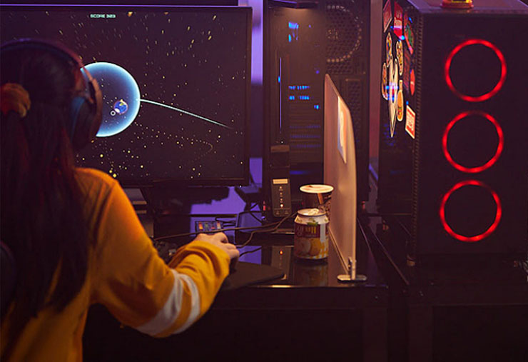 Girl playing space video game on desktop