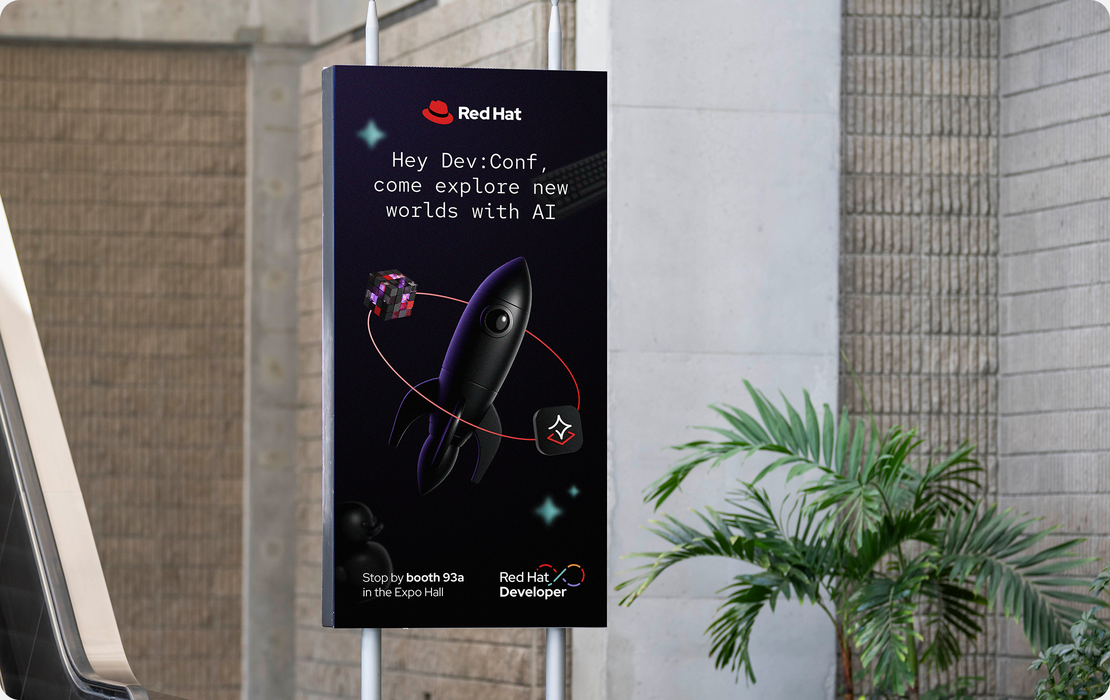 A poster at a conference called DevConf advertising the Red Hat Developer booth. The poster has the Red Hat logo prominent at the top and the Red Hat Developer logo in the bottom right corner.