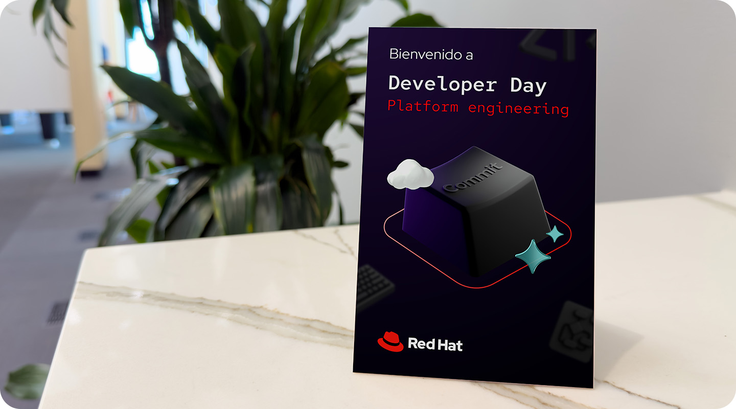A table tent sitting on a marble countertop, advertising Red Hat Developer Day for platform engineering.
