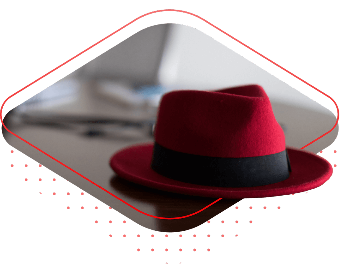 A red fedora sits on a desk, framed by a stylized red diamond shape