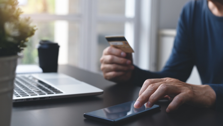 Image d'une personne qui utilise son téléphone et sa carte de crédit pour des services bancaires