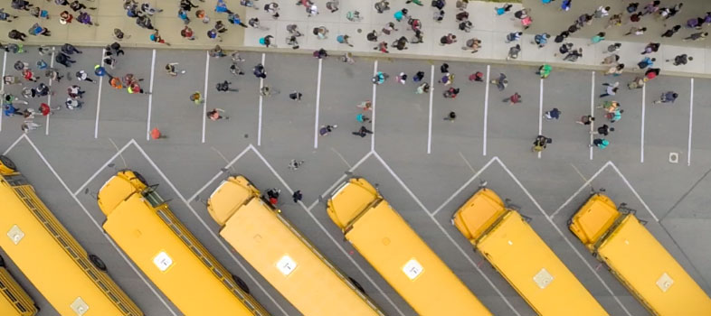 Visão aérea de ônibus escolares e alunos