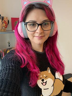 A photograph of Noe wearing pink headphones