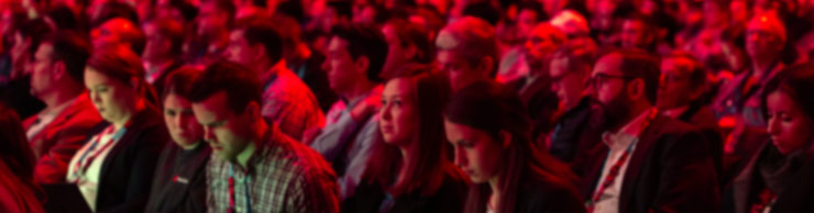 Red Hat Summit crowd with red lighting