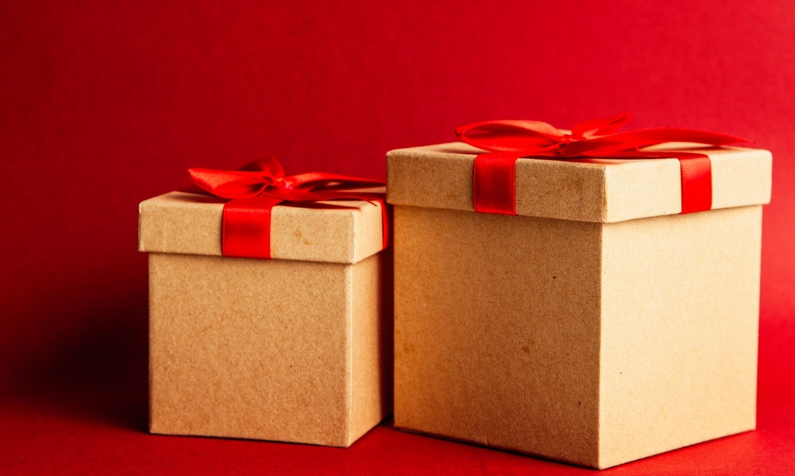 Two packages with red ribbon on red background