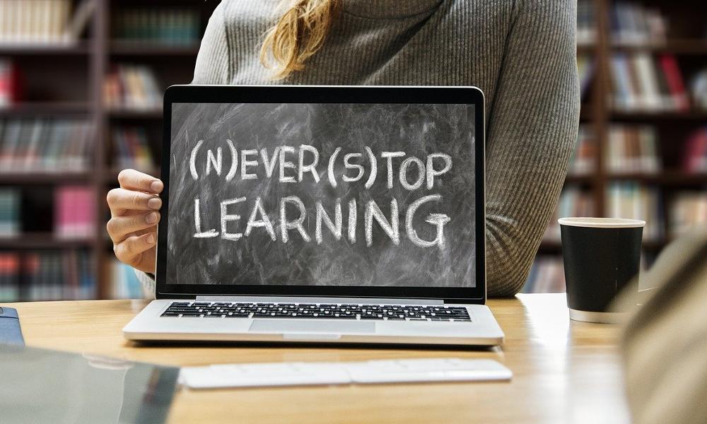 Never stop learning in chalk displayed on a laptop